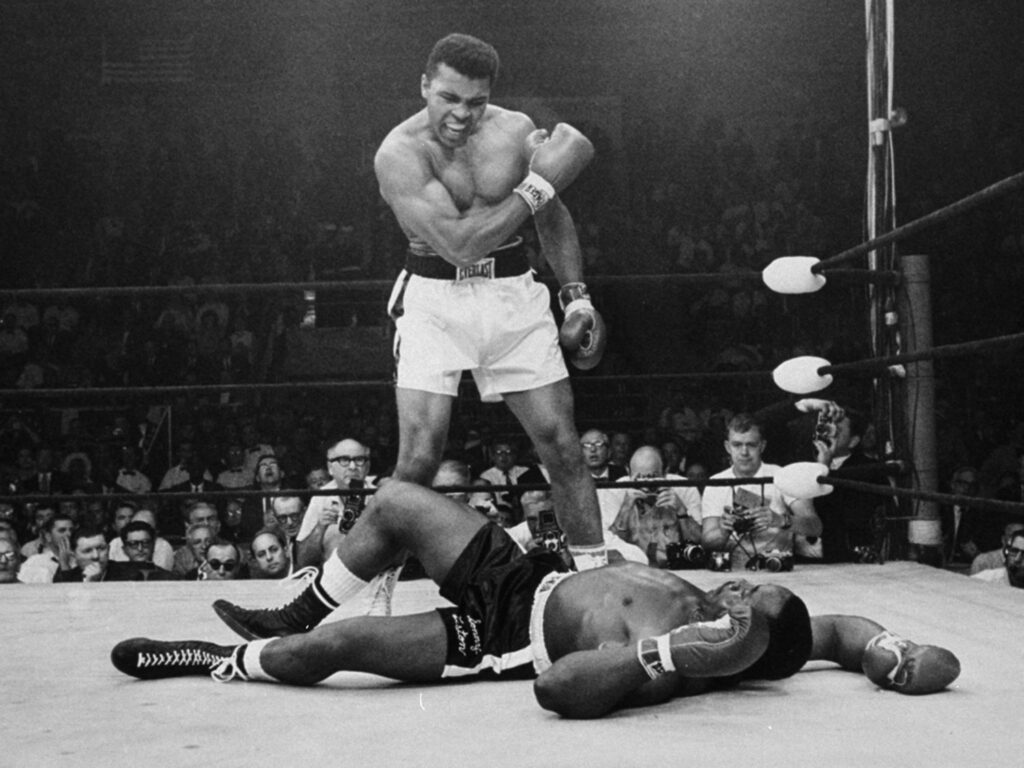 Historické momenty športu – Muhammad Ali stojí nad Sonnym Listonom po ikonickom knokaute.