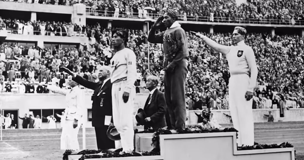 Historické momenty športu – Jesse Owens oslavuje víťazstvo na Olympijských hrách v Berlíne 1936.
